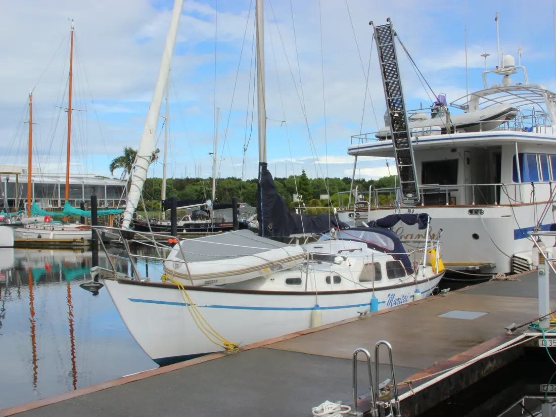 A sailboat moored alongside a marina pontoon