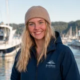 A BlueWave Marine team member in a BlueWave jacket at a marina